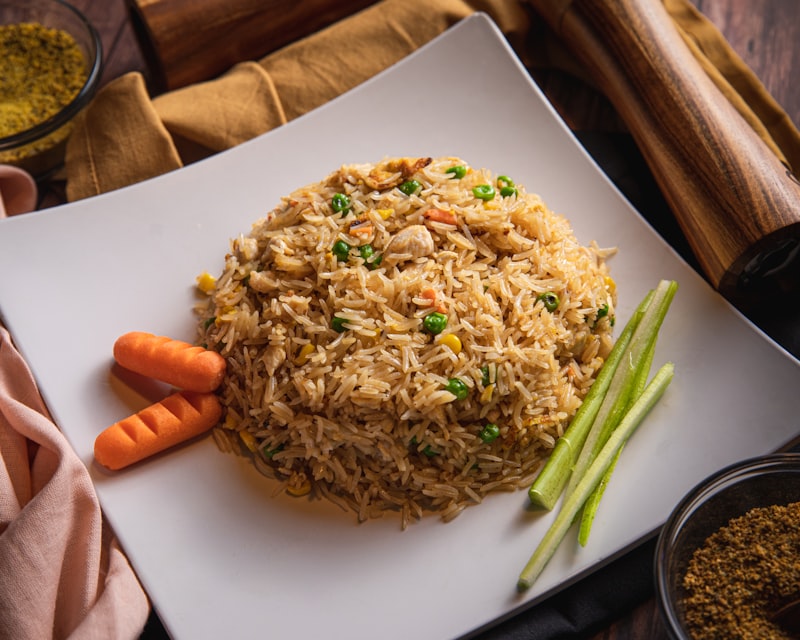 A plate of fried rice with vegetables